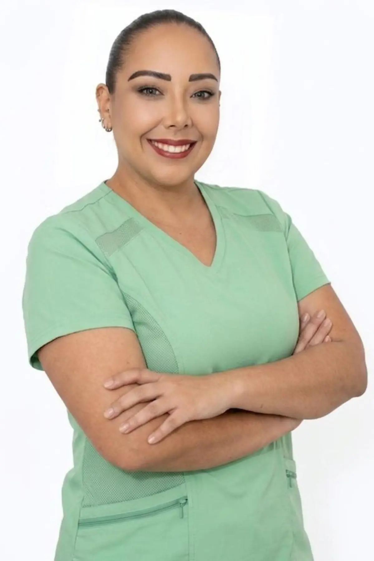 Retrato profesional de Legna Rodríguez con uniforme clínico verde